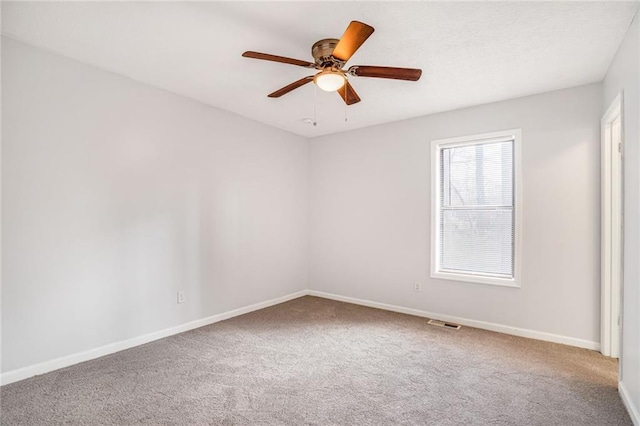 carpeted spare room with visible vents, a textured ceiling, baseboards, and a ceiling fan