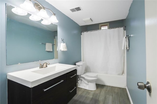 bathroom with visible vents, toilet, shower / bath combo, vanity, and wood finished floors