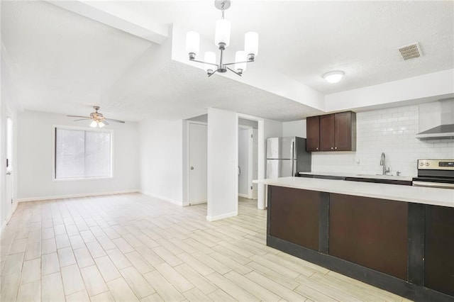 kitchen with visible vents, light countertops, stainless steel electric range oven, wall chimney exhaust hood, and tasteful backsplash