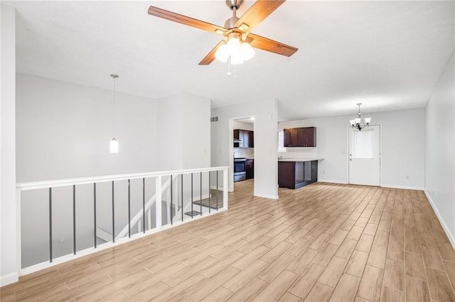 spare room with light wood-type flooring, baseboards, and ceiling fan with notable chandelier