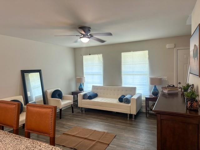 living room featuring a ceiling fan and wood finished floors