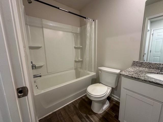 bathroom with vanity, wood finished floors, toilet, baseboards, and shower / tub combo