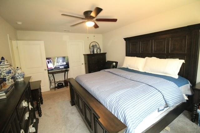 bedroom with a ceiling fan and light colored carpet