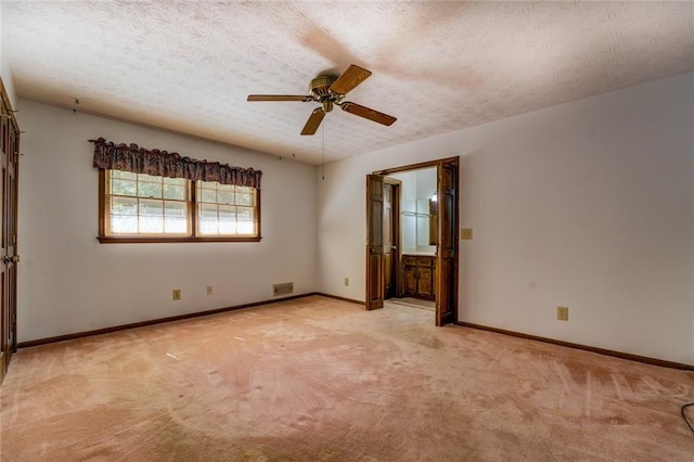 empty room featuring light colored carpet, a textured ceiling, and ceiling fan