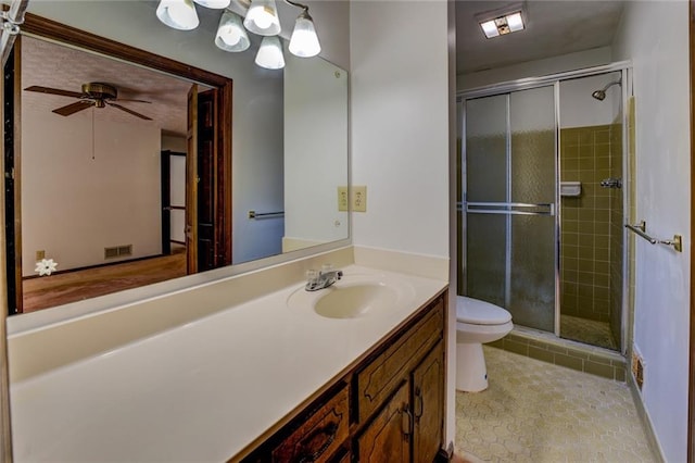 bathroom featuring toilet, tile patterned flooring, vanity, ceiling fan, and a shower with shower door