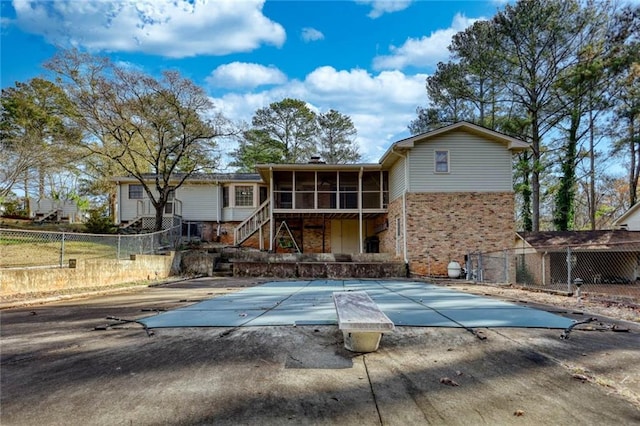 back of house with a patio, a sunroom, and a covered pool