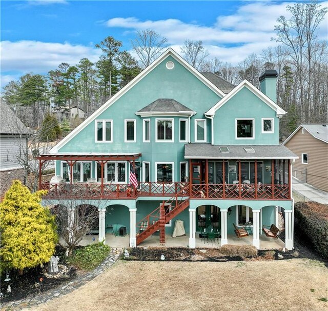 rear view of property with a sunroom and a patio area