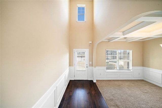 entryway featuring beamed ceiling, dark wood-type flooring, coffered ceiling, and a healthy amount of sunlight