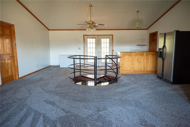 carpeted spare room featuring ceiling fan, lofted ceiling, ornamental molding, and french doors