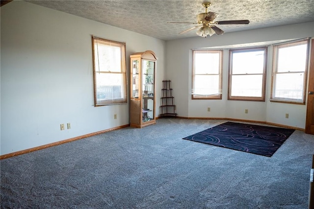 unfurnished room featuring ceiling fan, carpet floors, and a textured ceiling