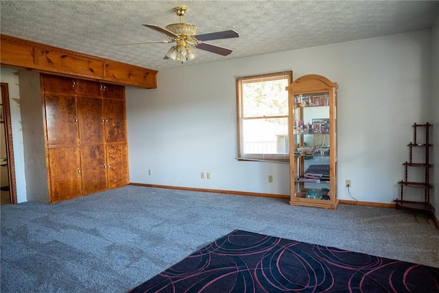 unfurnished bedroom with ceiling fan, carpet floors, and a textured ceiling