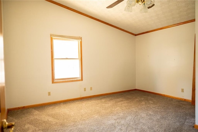 empty room featuring ceiling fan, carpet floors, crown molding, and vaulted ceiling