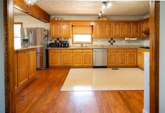 kitchen featuring a textured ceiling, light stone countertops, dark hardwood / wood-style floors, and appliances with stainless steel finishes