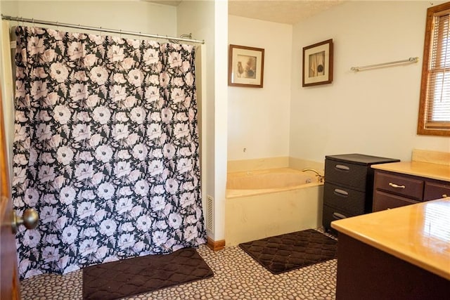 bathroom with vanity and independent shower and bath