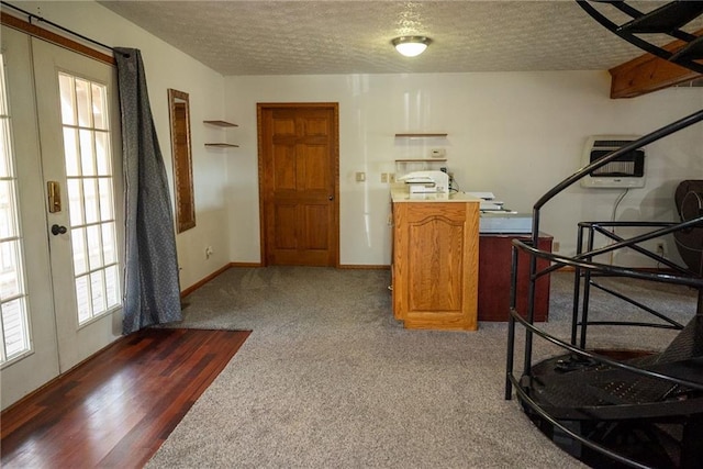 interior space featuring dark carpet, french doors, a textured ceiling, and heating unit