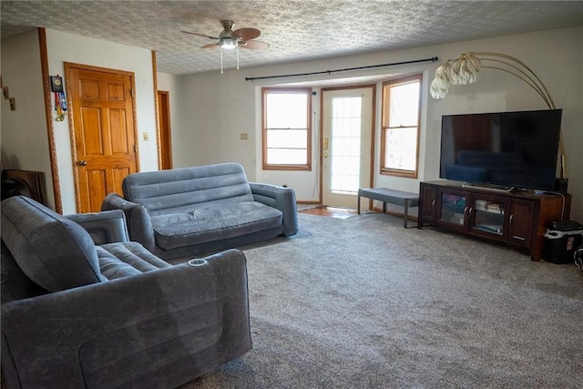 living room featuring carpet flooring, ceiling fan, and a textured ceiling