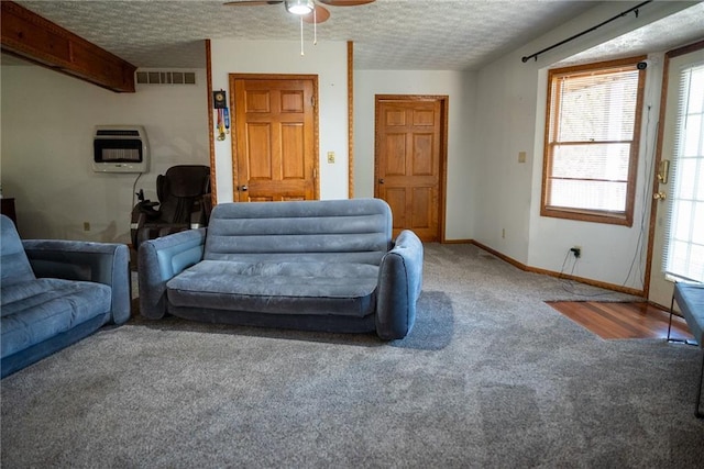 carpeted living room with ceiling fan, a textured ceiling, and heating unit