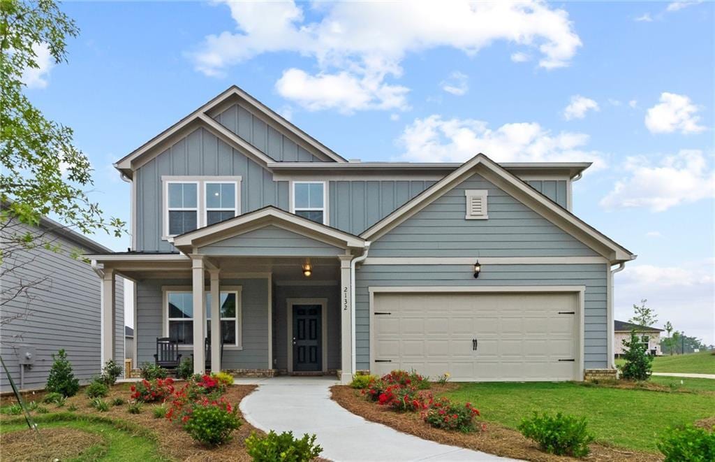 craftsman-style home featuring a porch, a garage, and a front yard