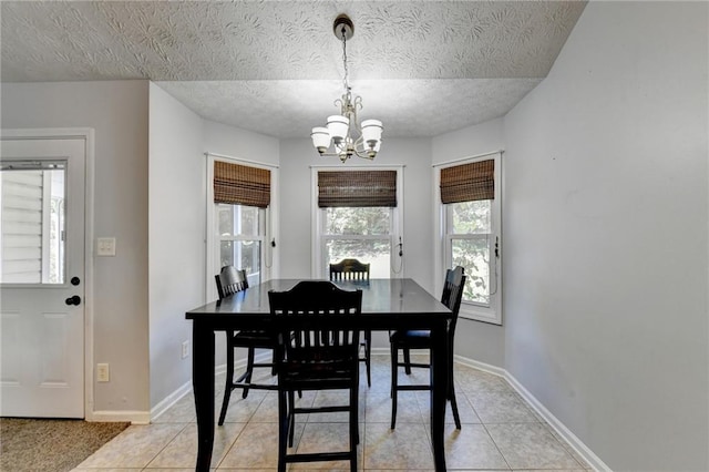 tiled dining area with a textured ceiling and a chandelier