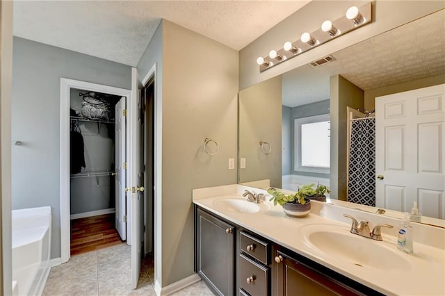 bathroom with vanity, a textured ceiling, tile patterned floors, and separate shower and tub