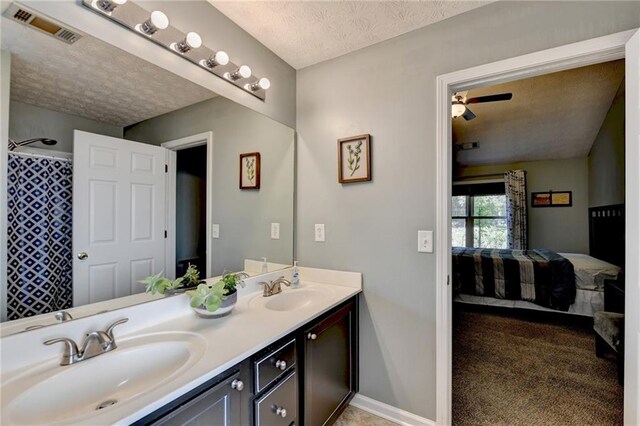 bathroom featuring vanity, curtained shower, a textured ceiling, and ceiling fan