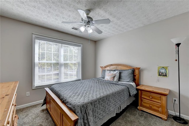 bedroom featuring dark colored carpet, a textured ceiling, and ceiling fan