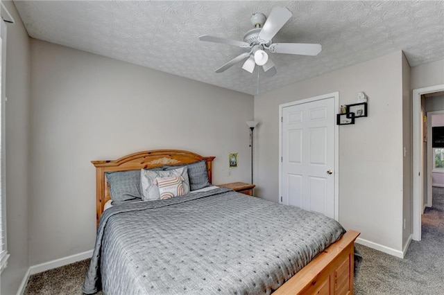 carpeted bedroom with a textured ceiling and ceiling fan