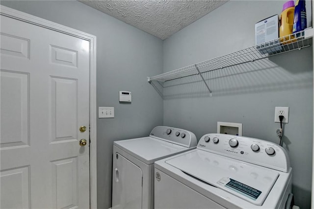 laundry area featuring a textured ceiling and separate washer and dryer