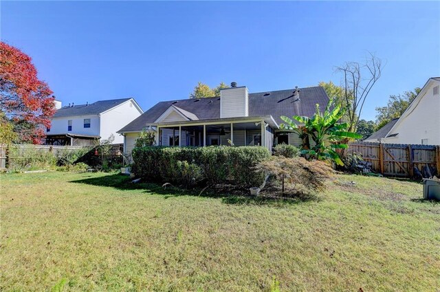 rear view of property with a yard