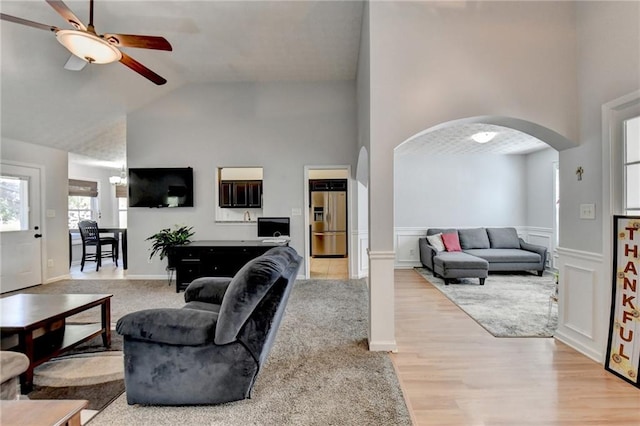 living room featuring high vaulted ceiling, light wood-type flooring, and ceiling fan