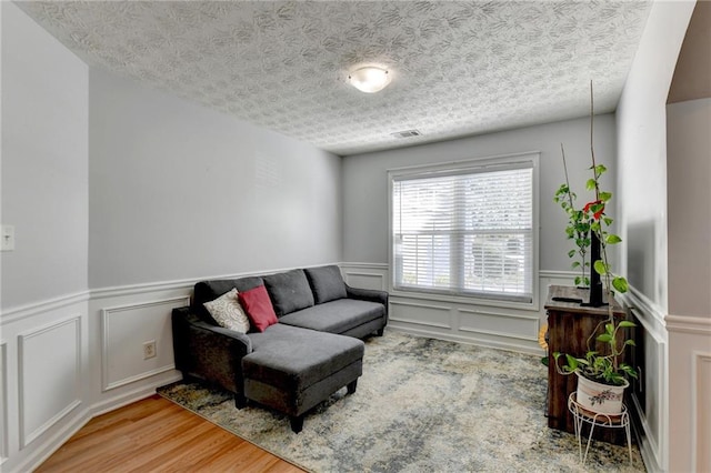 sitting room featuring hardwood / wood-style flooring and a textured ceiling