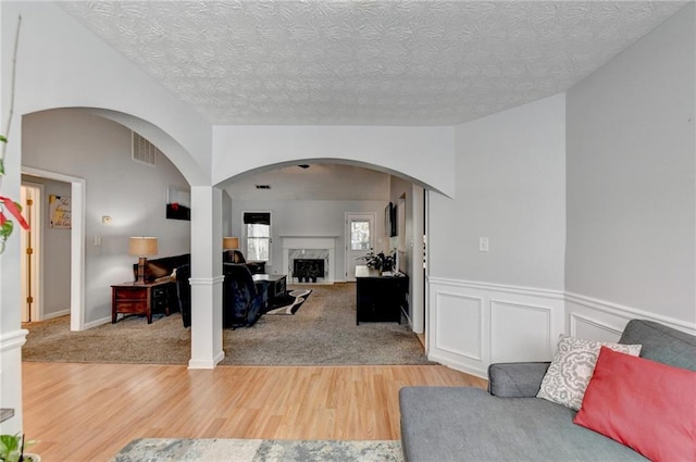 living room with a premium fireplace, hardwood / wood-style floors, and a textured ceiling