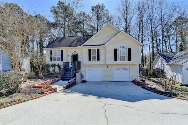 raised ranch featuring an attached garage and concrete driveway