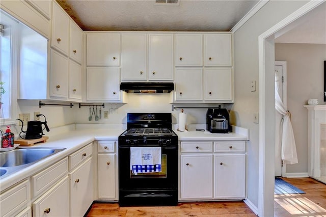 kitchen with white cabinets, under cabinet range hood, and black range with gas stovetop