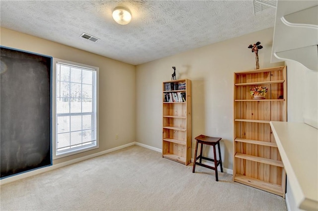 interior space featuring a textured ceiling, visible vents, and baseboards