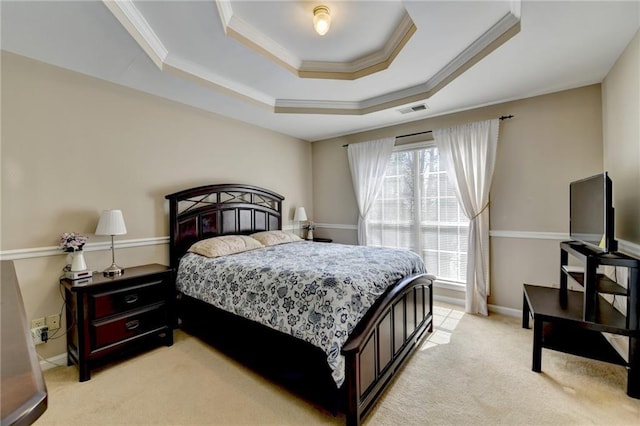 bedroom with a tray ceiling, light colored carpet, visible vents, ornamental molding, and baseboards