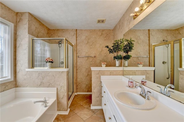 full bathroom with a stall shower, plenty of natural light, a garden tub, and a textured ceiling