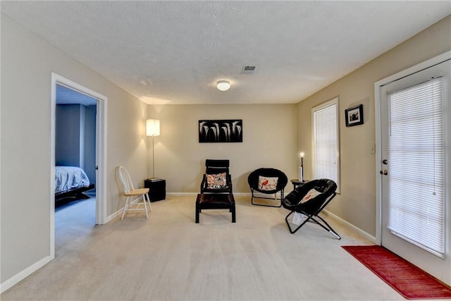 living area featuring plenty of natural light, carpet, and baseboards