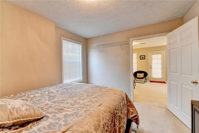 bedroom with light carpet and a textured ceiling