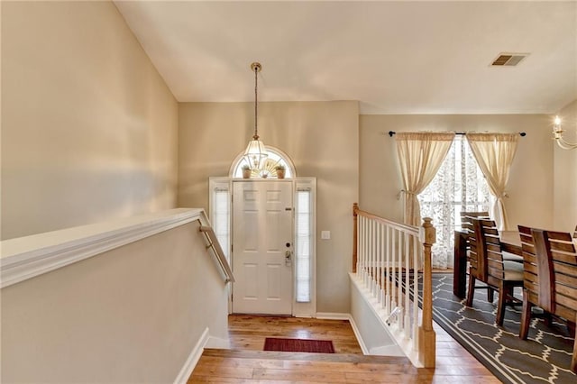 entryway with hardwood / wood-style floors, visible vents, and baseboards