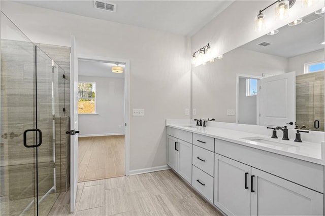bathroom with visible vents, a stall shower, and a sink