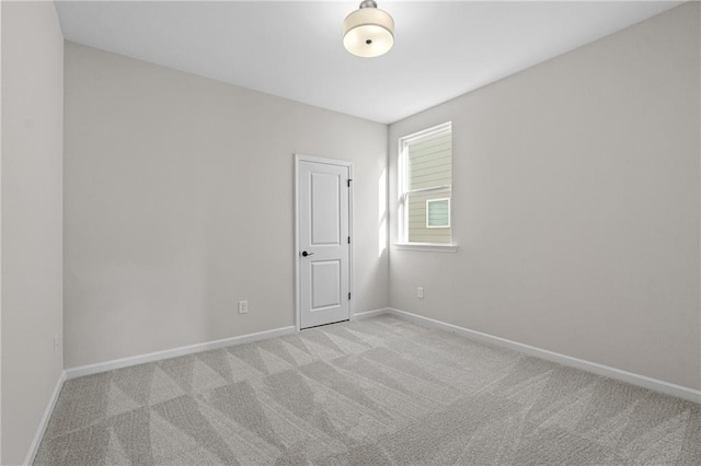 carpeted spare room featuring baseboards