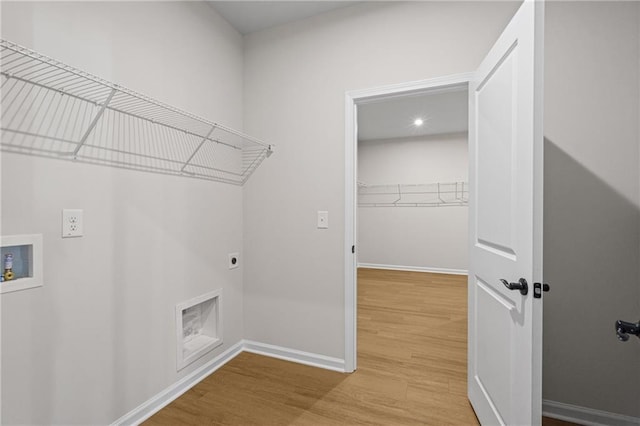 laundry area featuring electric dryer hookup, laundry area, hookup for a washing machine, baseboards, and light wood-style floors