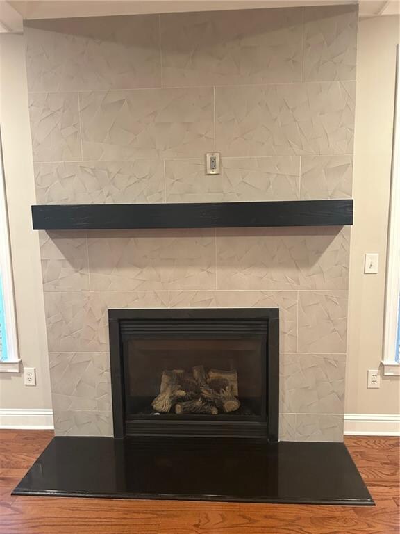 details with hardwood / wood-style floors and a tile fireplace