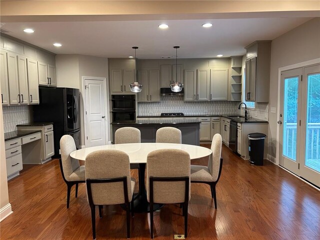 kitchen with hanging light fixtures, sink, a kitchen island, dark wood-type flooring, and gray cabinets