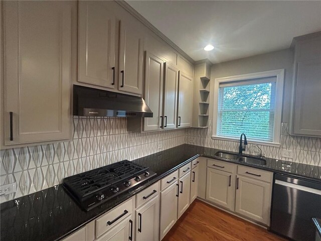 kitchen featuring dishwasher, dark hardwood / wood-style floors, sink, gas cooktop, and decorative backsplash