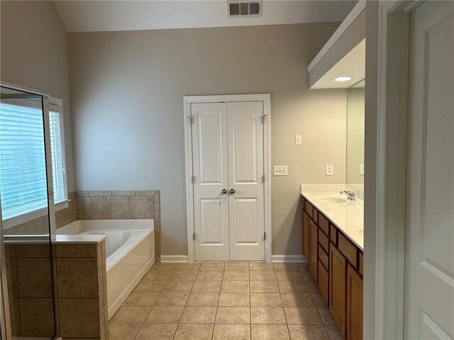 bathroom featuring a tub to relax in, tile patterned flooring, and vanity