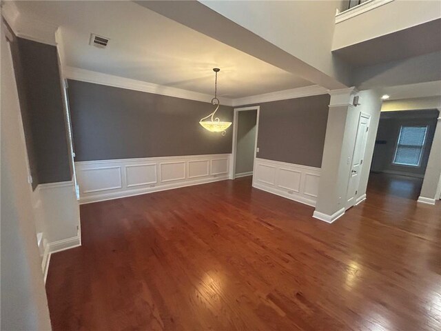 unfurnished dining area with ornamental molding, decorative columns, and dark hardwood / wood-style flooring