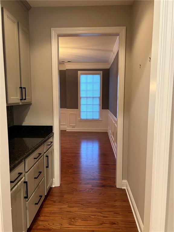 hall featuring crown molding and dark wood-type flooring