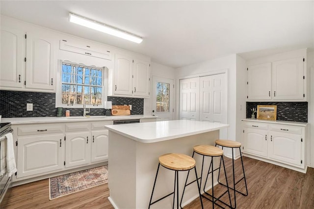 kitchen with a kitchen island, plenty of natural light, white cabinetry, and wood-type flooring